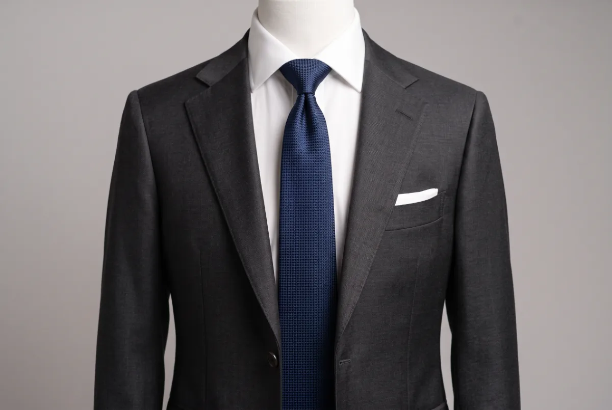 Terno cinza com camisa branca e gravata azul-escura